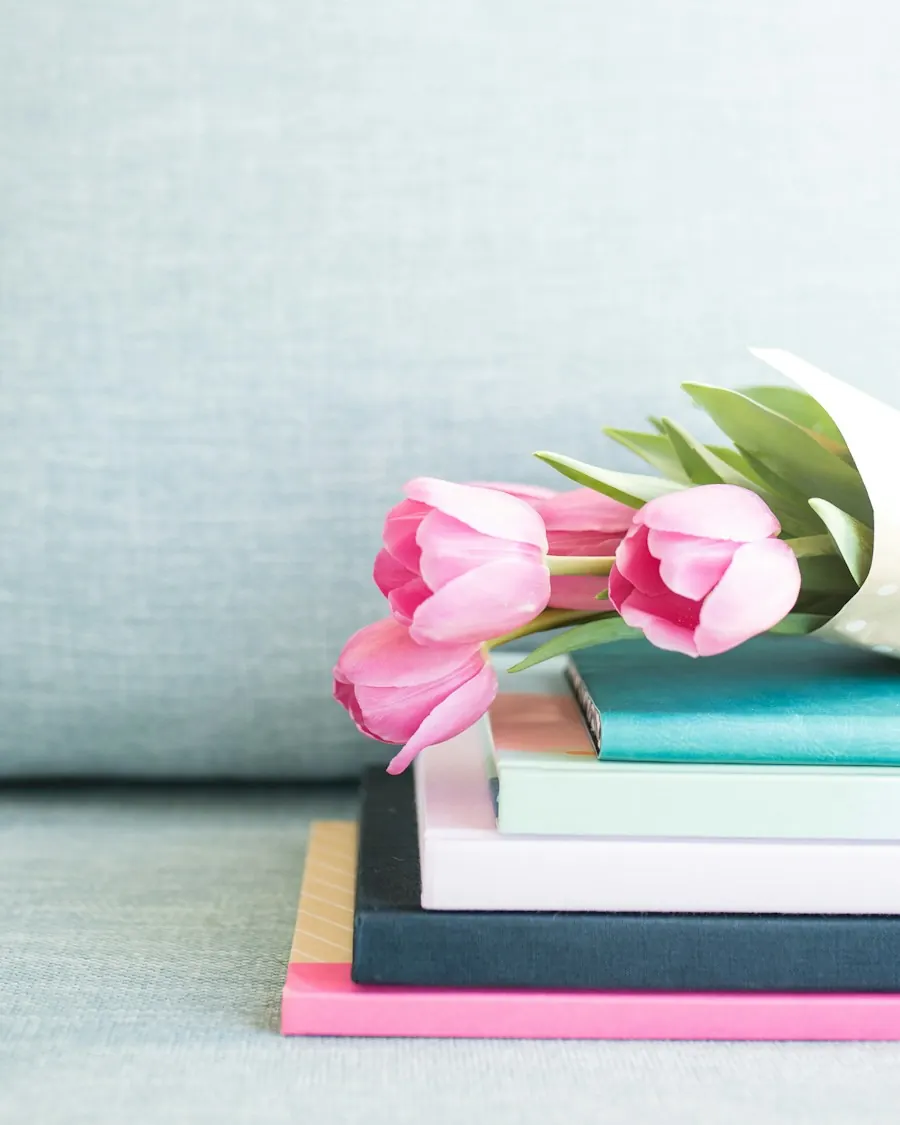 Pink tulips resting on a stack of books